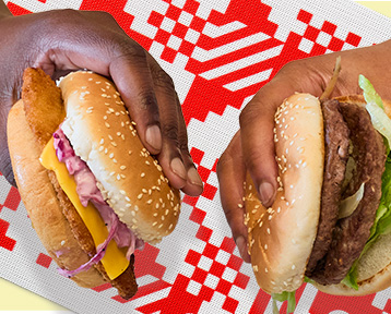 Two hands holding burgers
